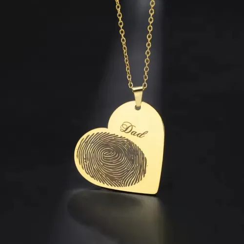 Close-up of men’s fingerprint heart necklace on gold chain, engraved with loved one’s fingerprint.