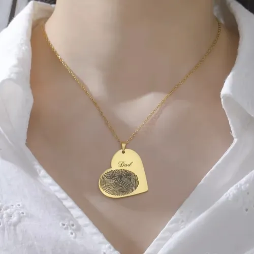 Woman wearing a heart-shaped custom fingerprint necklace with engraved name, meaningful keepsake jewelry.