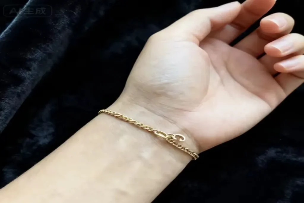 What Is Permanent Jewelry: jeweler using a micro welder to attach a gold chain bracelet onto a client’s wrist.